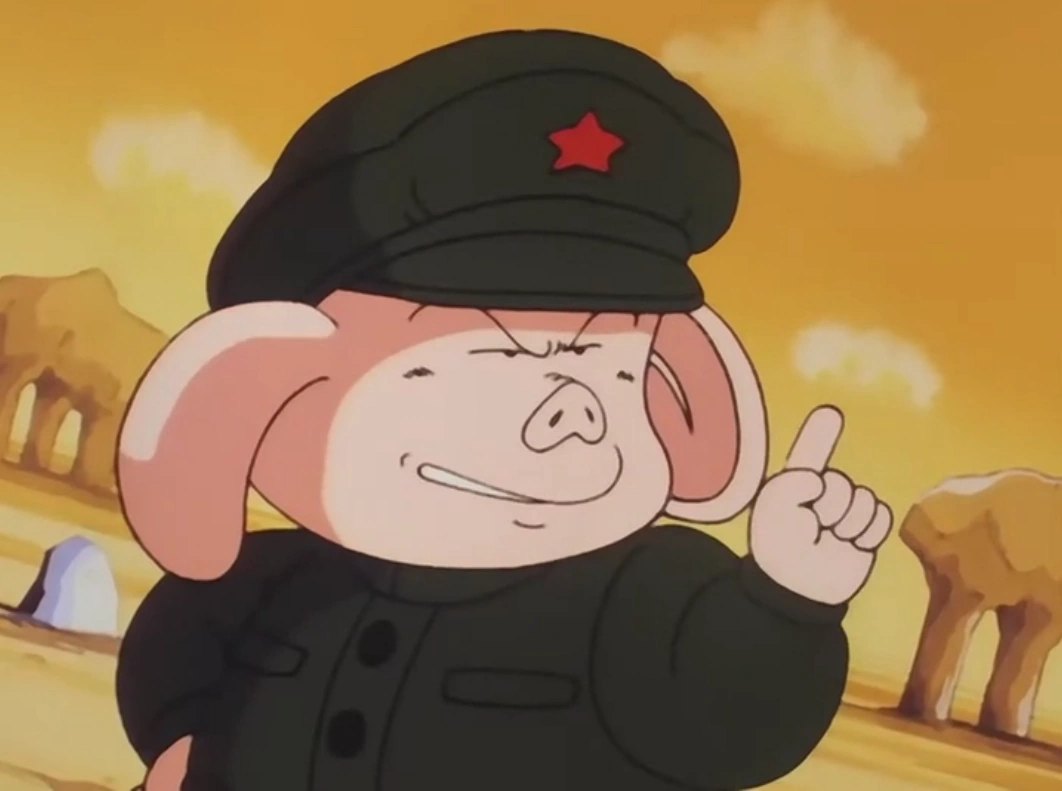 Oolong, petit cochon rose en uniforme et casquette verts à étoile rouge, sourire en coin et index levé, dans un désert ocre.